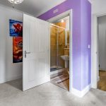 Bathroom entrance in colourful room with posters.
