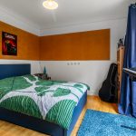 Modern bedroom with bed, guitar, and keyboard