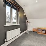 Small room with window, radiator, storage, and hanger.