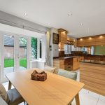 Modern kitchen with wooden cabinets and garden view.