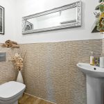 Modern bathroom with mirror and decorative items.