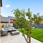 Modern garden with patio and apple tree.