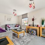 Modern living room with grey sofas and colourful decor.