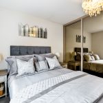 Modern bedroom with mirrored wardrobe and chandelier