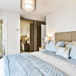 Modern bedroom with ensuite bathroom and soft lighting.