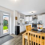 Modern kitchen-diner with garden view and wooden furniture.