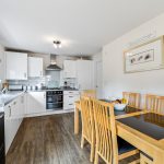 Modern kitchen and dining area with wooden furniture.