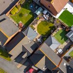 Aerial view of suburban houses with gardens.