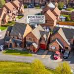 Aerial view of suburban houses, one for sale.