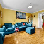 Bright living room with blue sofas and yellow walls.