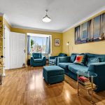 Cosy living room with teal sofas and wooden floor.