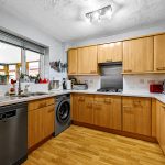 Modern kitchen with wood cabinets and appliances.