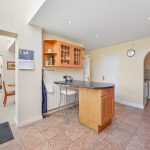 Modern kitchen with breakfast bar and tiled floor.