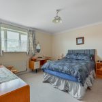 Cosy bedroom with double bed and wooden furniture.