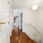 Bright hallway with wooden floor and staircase.