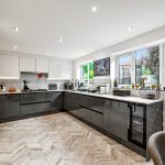 Modern kitchen with large windows and sleek design.