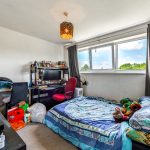 Cosy bedroom with desk and computer setup.