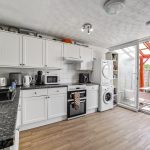 Modern kitchen with appliances and garden view.