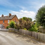 Red brick house on a quiet suburban street.