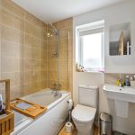 Modern bathroom with bathtub and tiled wall.