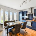 Modern kitchen with blue cabinets and dining area.