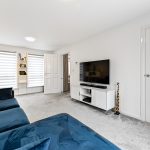 Modern living room with blue sofa and TV.