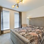 Modern bedroom with patterned bedding and ceiling light