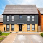 Modern two-storey house with driveway and garden.