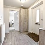 Modern hallway with wooden floors and storage cabinets.