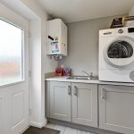 Modern utility room with washing machine and sink.