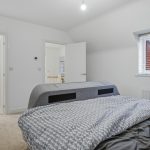 Modern bedroom with double bed and grey decor.