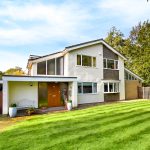 Modern house with green lawn and trees