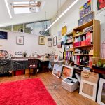 Cosy art studio with paintings and art supplies.