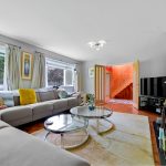 Spacious modern living room with large windows and sofa.