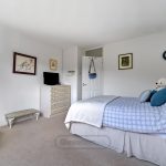 Cosy bedroom with bed, dresser, and artwork