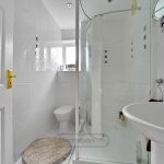 Modern white bathroom with shower and sink.