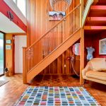 Colourful modern hallway with wooden staircase interior.