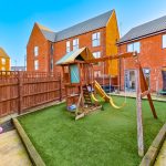 Children's playground set in residential backyard garden.