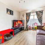 Living room with fireplace on TV screen.
