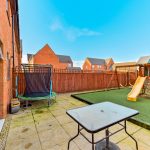 Modern garden with play area and trampoline.