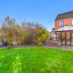 Back garden with patio and conservatory