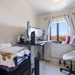 Home office with desk and window view.