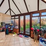 Conservatory with shoes, garden view, and storage racks.