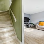 Modern living room and staircase with wooden flooring.