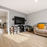 Modern living room with TV and beige sofa.