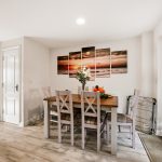 Dining room with table, chairs, and wall art.