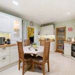 Modern kitchen with wooden dining table and chairs.