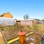 Vegetable garden with polytunnel and compost bin.