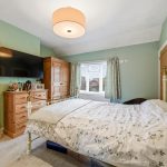 Cosy bedroom with wooden furniture and floral bedspread.
