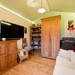 Cosy living room with wooden furniture and large TV.